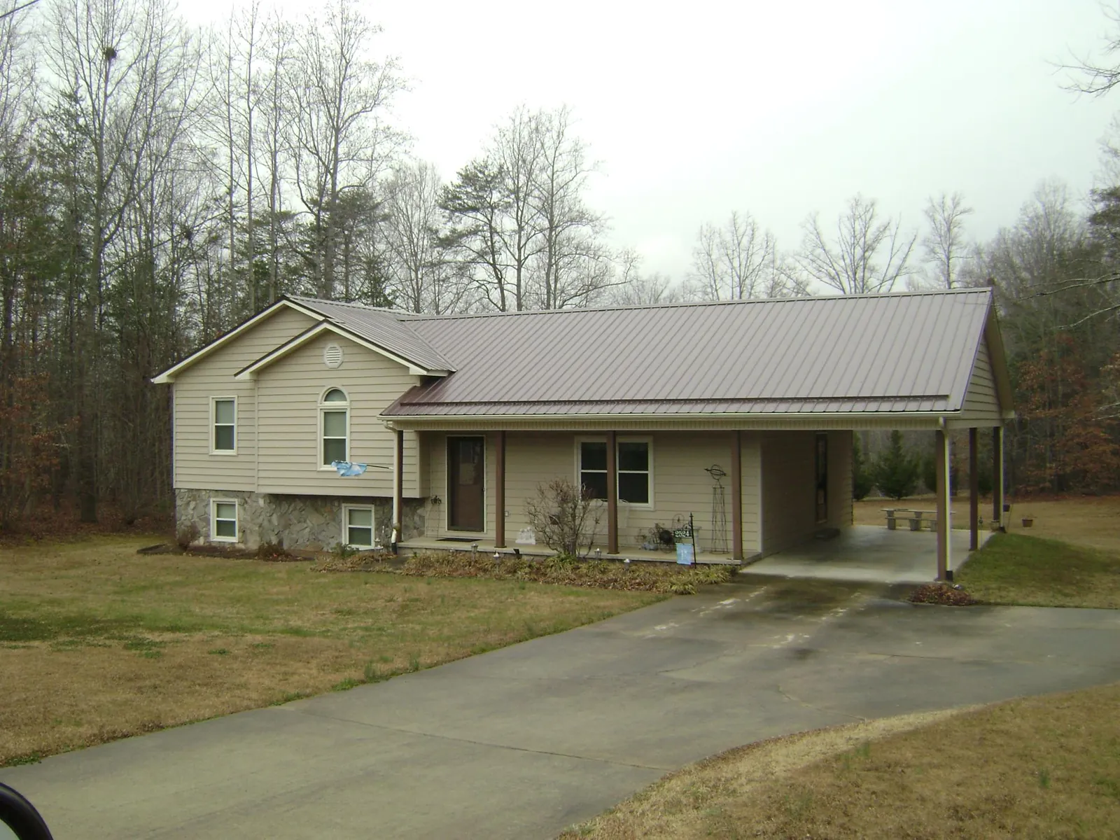 Brown metal roof on a tan split level home with an attached carport in Plymouth